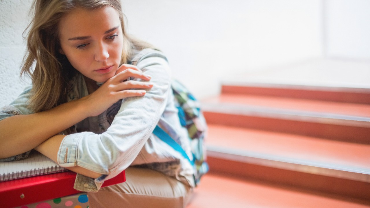 Sad lonely student sitting on stairs